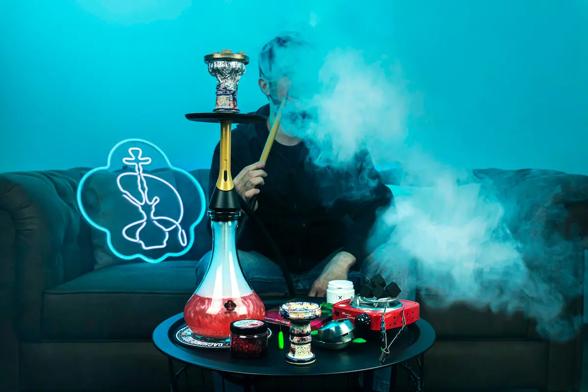 Shisha mit Tabak, Kohlen und Zubehör auf einem Lounge-Tisch